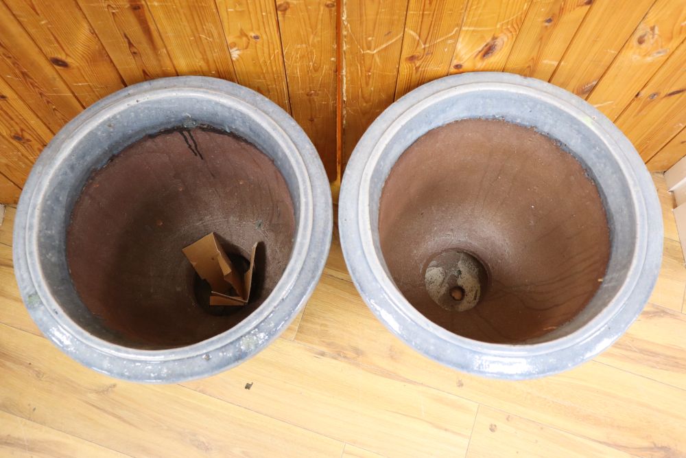 A pair of blue glazed terracotta pots, with swag design, height 51cm